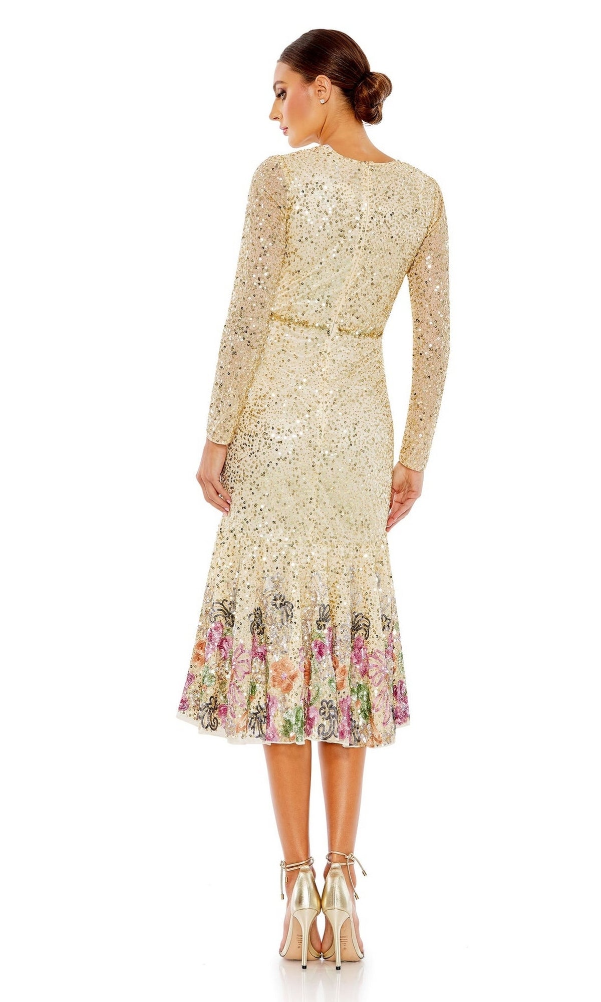 A woman with her hair in a low bun, seen from behind, wears the Mac Duggal 5589 Beaded Midi Wedding Guest Dress, featuring long sleeves, gold sequins, and floral patterns at the hem.